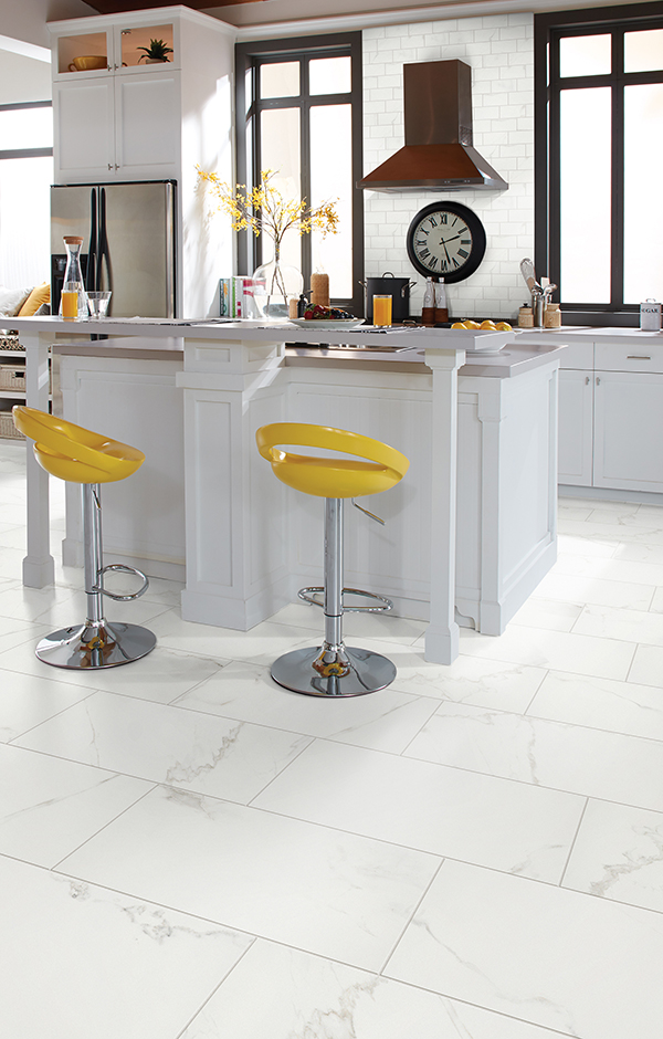large white floor tiles in a modern kitchen with yellow bar stools